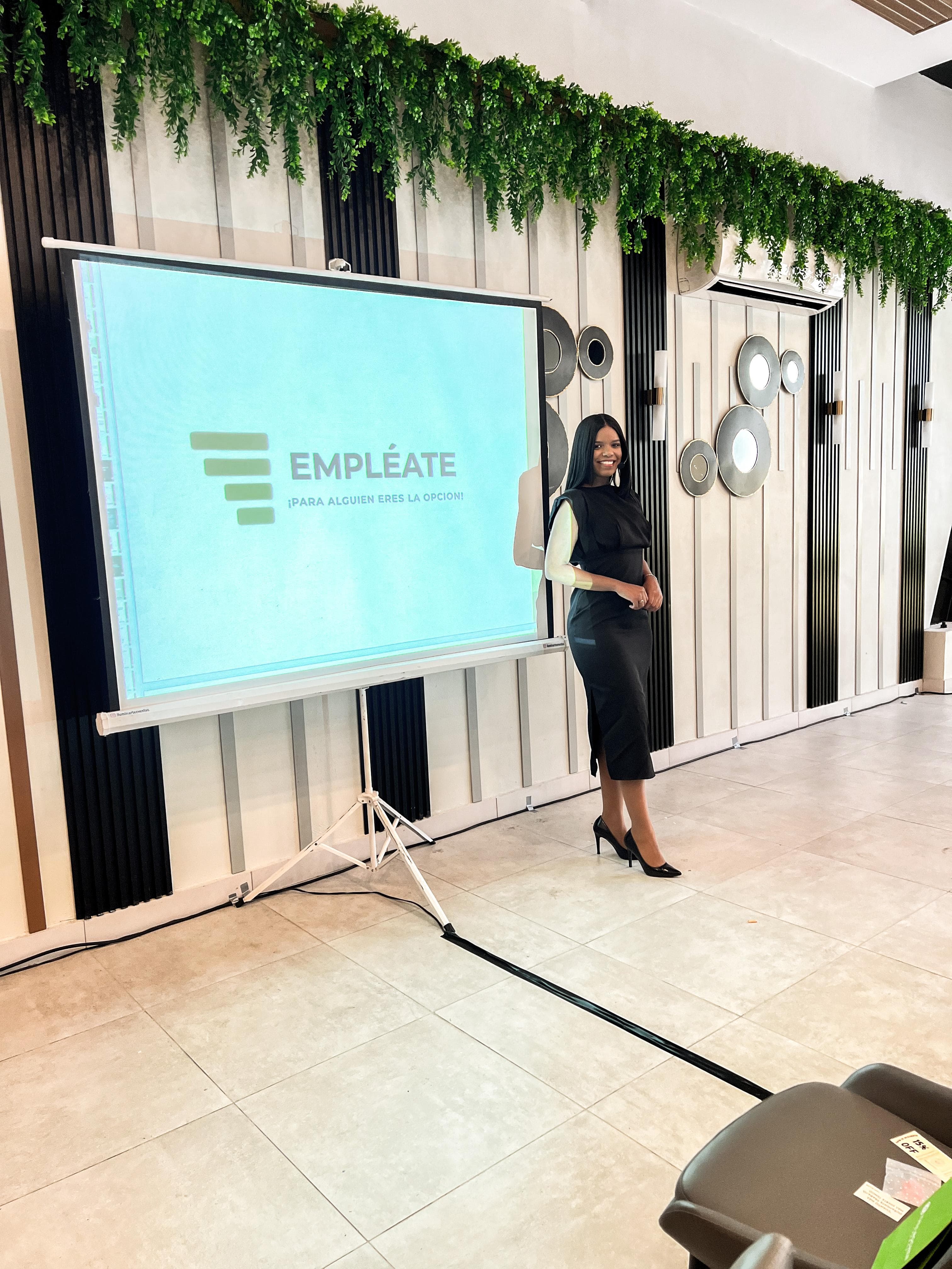 Fundadora de Empléate presentando frente a una pantalla con el logo